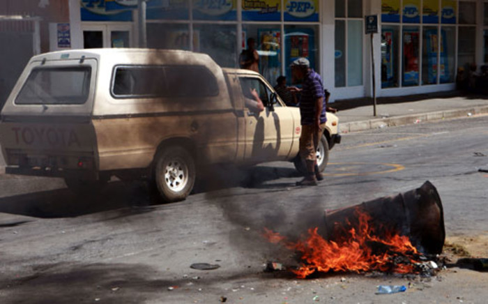 A protester confronts a farmer in a bakkie while others (unseen) block the main road in Swellendam with burning obstacles on15 November 2012. Picture:Nardus Engelbrecht/SAPA