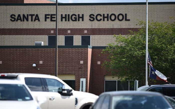 A flag flies at half-staff at Santa Fe High School on 19 May 2018 in Texas. The gunman, arrested on murder charges, was identified as Dimitrios Pagourtzis, a 17-year-old junior at the school. He is being held on capital murder charges, meaning he could face the death penalty. Picture: AFP.