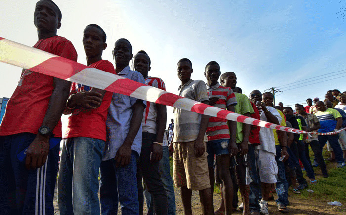 People wait in line prior to casting their vote for Liberia's presidential and legislatives elections at a polling station in Monrovia on 10 October 2017. Picture: AFP.