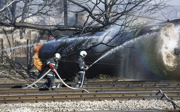 Firefighters spray water on a train which derailed in the northeastern Bulgarian village of Hitrino on December 10, 2016. Picture:  AFP.