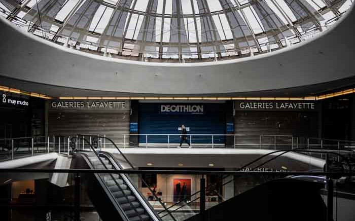 FILE: A person walks in the empty Lyon Part Dieu mall in Lyon on 17 March 2020, as a strict lockdown comes into effect in France to stop the spreading of COVID-19, caused by the novel coronavirus. A strict lockdown requiring most people in France to remain at home came into effect at midday on 17 March 2020, prohibiting all but essential outings in a bid to curb the coronavirus spread. Picture: AFP.
