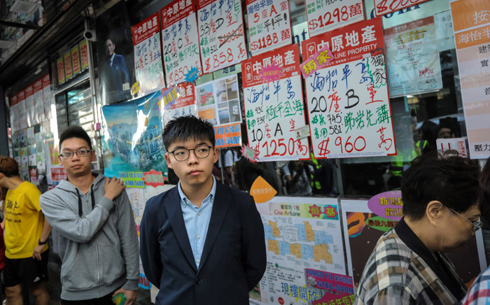 Pro-democracy activist Joshua Wong (C), who was disqualified from running, queues up to cast his vote during district council elections in the South Horizons district in Hong Kong on 24 November 2019. Picture: AFP