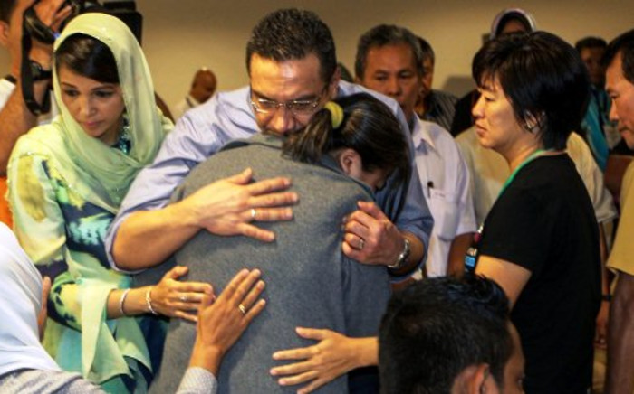 Malaysia's Minister of Defence and Acting Transport Minister Hishammuddin Hussein (C) hugs a relative of the missing Malaysia Airlines flight MH370 during his visit at a hotel in Putrajaya on March 29, 2014. Picture: AFP.