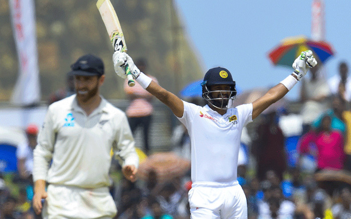 Sri Lanka's cricket team captain Dimuth Karunaratne (R) celebrates after scoring a century (100 runs) during the final day of the first Test cricket match between Sri Lanka and New Zealand at the Galle International Cricket Stadium in Galle on 18 August 2019.  Picture: AFP