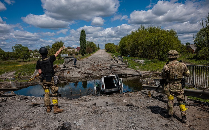 FILE: Kraken Ukrainian special forces unit Soldiers talk to a man at a destroyed bridge on the road near the village of Rus'ka Lozova, north of Kharkiv, on May 16, 2022.  Picture: Dimitar DILKOFF / AFP.