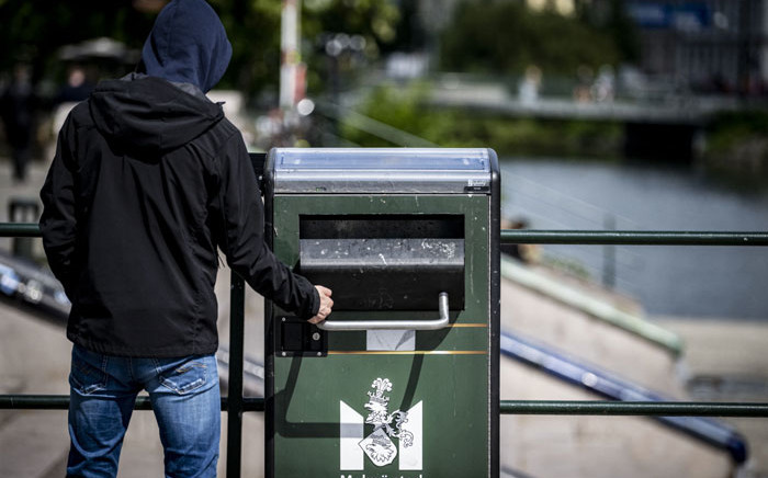 A pedestrian throws trash into a speaking garbage can at the David Hall bridge in Malmo, Sweden on 8 June 2022. Picture: Johan NILSSON/TT News Agency/AFP
