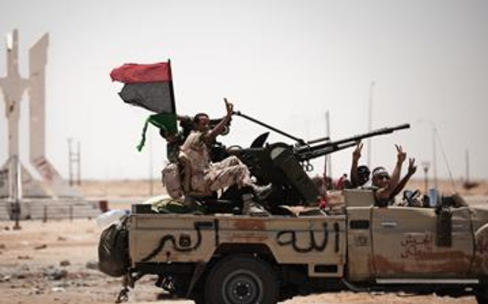 Libyan rebel fighters flash the victory sign as they drive on 11 June 2011 in Ajdabiya. AFP 