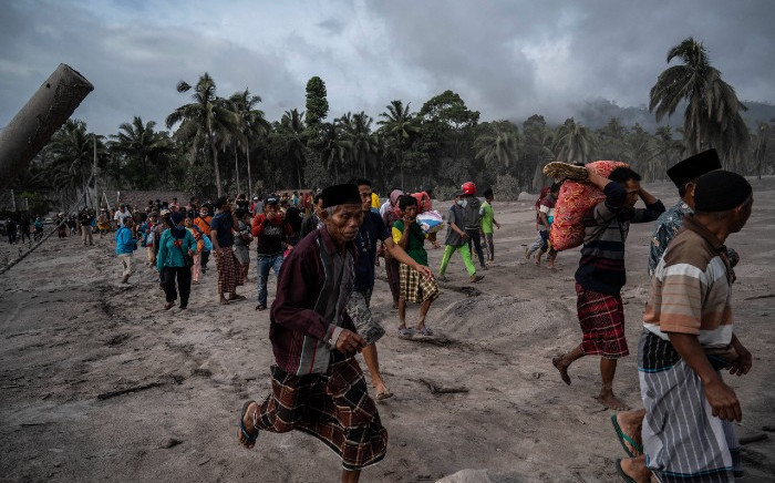 Villagers salvage their belongings in an area covered in volcanic ash at Sumber Wuluh village in Lumajang on 5 December 2021, after the Semeru volcano eruption that killed at least 13 people. Picture: AFP