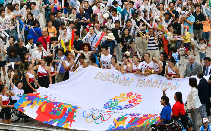 FILE: People gathered at the Tokyo metropolitan government building celebrate and carry a banner after Tokyo won its bid to be the host city of the 2020 Olympics on 8 September 2013. Picture: AFP.