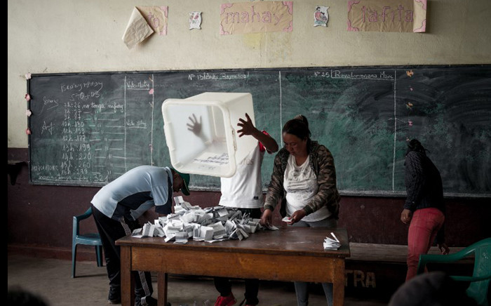 An electoral officer empties a ballot box during the counting of the ballots for the second round of Madagascar's presidential election at a polling station in Antananarivo on 19 December 2018. Madagascar voted on 19 December in a two-man contest between former presidents who have waited years to come face-to-face in a fiercely personal battle for power in the Indian Ocean island. Picture: AFP