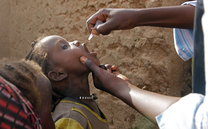 A child receives the polio vaccine from a vaccination team in the Al Salam IDP camp, North Darfur, Sudan. Picture: United Nations Photo.