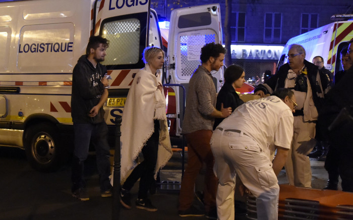 Rescue workers evacuate injured people near the Bataclan concert hall in central Paris, on November 13, 2015. At least 39 people were killed in an "unprecedented" series of bombings and shootings across Paris and at the Stade de France stadium on November 13.  Picture: AFP