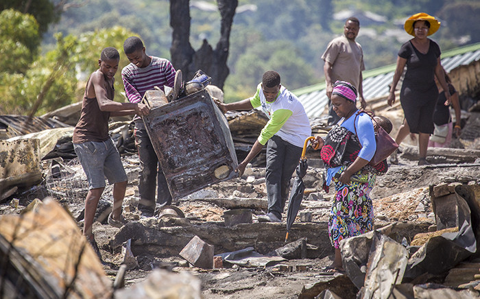 FILE: Residents of the Imizamo Yethu informal settlement in Hout Bay, Cape Town, help to clear the rubble after a fire ripped through a section. Picture: Aletta Harrison/EWN.