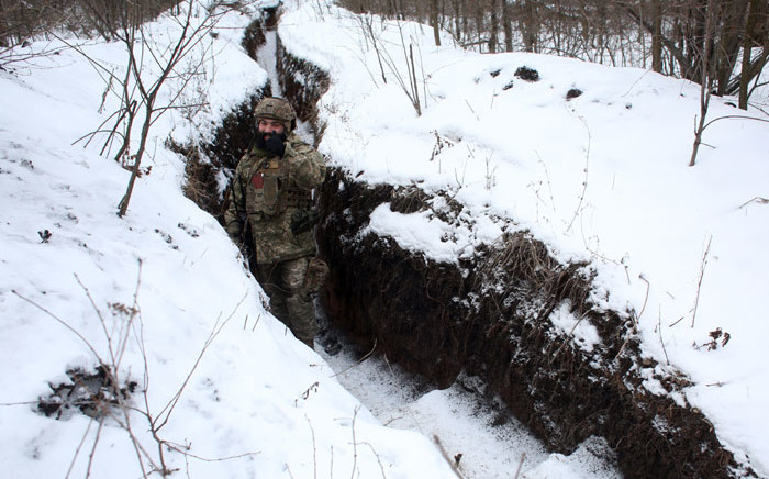 A Ukrainian Military Forces serviceman gives the thumbs-up as he stands in a snow-covered trench on the frontline with the Russia-backed separatists near Zolote village, in the eastern Lugansk region, on 21 January 2022. Picture: Anatolii STEPANOV/AFP