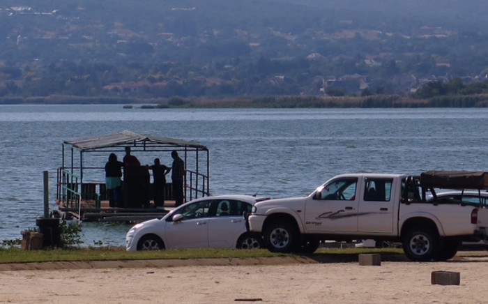 Family gather with the recovered body of 23-month-old toddler, who is presumed to have drowned after falling out of capsized boat yesterday, into Hartbeespoort Dam on 11 May 2015. Picture: Louise McAuliffe/EWN.