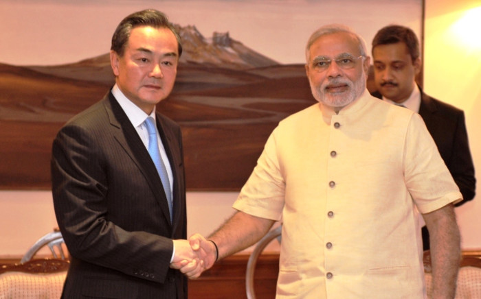 Chinese Foreign Minister Wang Yi (L) and Indian Prime Minister Narendra Modi (R) shake hands during a meeting in New Delhi. Picture: AFP.