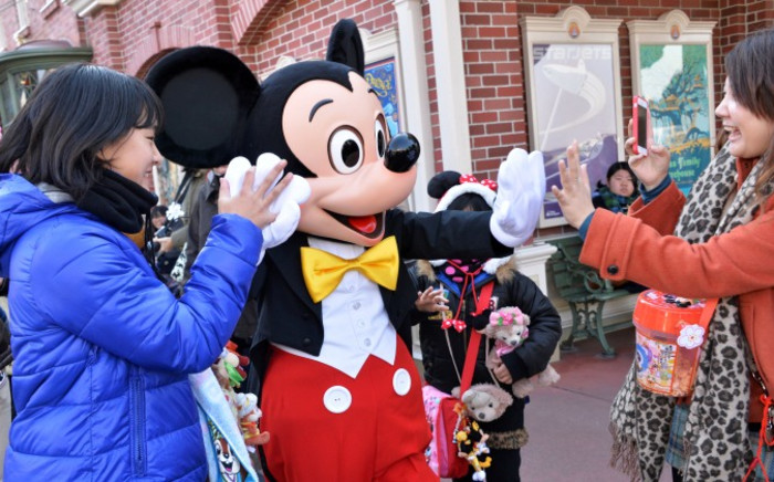 Disney character Mickey Mouse (C) exchange greetings with guests at Tokyo Disneyland in Urayasu, suburban Tokyo on 1 Janury 2014. Picture: AFP