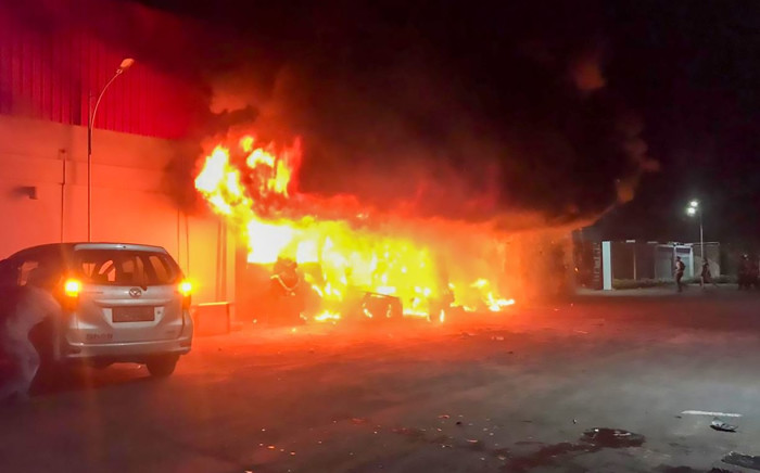A fire burns at the Double O nightclub where at least 18 people were killed in clashes between two groups, in Sorong in Indonesia's West Papua province on 25 January 2022. Picture: YANTI/AFP
