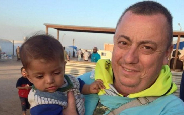 FILE: This handout image received from Britain’s Foreign and Commonwealth Office on 15 September, 2014 shows British aid worker, Alan Henning holding a child in a refugee camp on the Turkish-Syrian border. Picture: AFP.