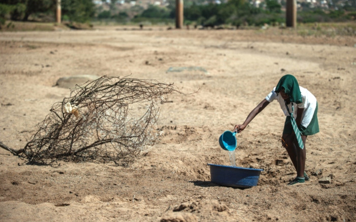 A school girl tries to collect water from a dry puddle in Nongoma, in KwaZulu-Natal, which has been badly affected by the recent drought. Picture: AFP.