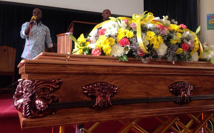 Bouquets of flowers draped over the casket with a picture of Kela when he graduated from the University of Johannesburg. Picture: Mia Lindeque/EWN.