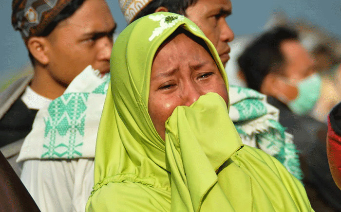 A woman cries as people look at the damages after an earthquake and a tsunami hit Palu, on Sulawesi island on 29 September 2018. Picture: AFP