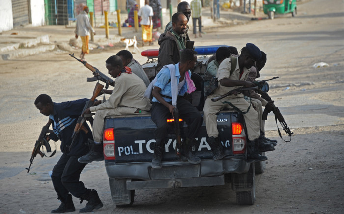 FILE: Somali government police officers arrive to secure the area of a suicide car bombing near the SYL hotel in Mogadishu on 22 January, 2015. Picture: AFP.