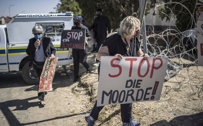 Demonstrators carry placards during a demonstration against farm attacks in Senekal, South Africa, on 16 October 2020, ahead of the appearance of suspects in the Senekal Magistrates Court for the murder case of 22-year-old farm manager Brendin Horner. Picture: AFP