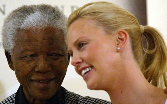 Former President Nelson Mandela with Oscar winner Charlize Theron in March 2004 in Johannesburg. Picture: AFP.