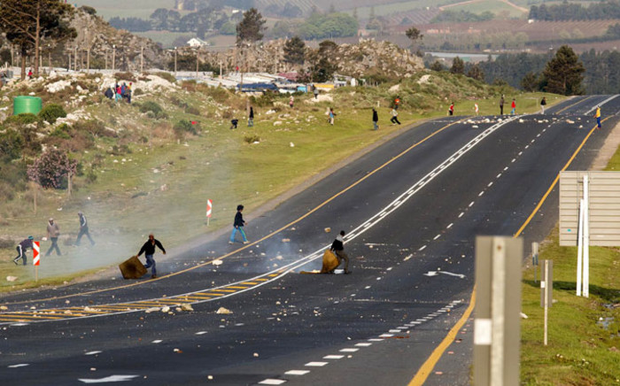 Protesters in Grabouw in the Western Cape block the road during a demonstration over the lack of housing, poor and expensive electricity supply and bad road conditions on Tuesday 16 September 2014. Picture: Sapa.