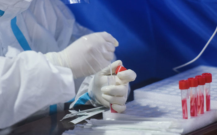 A medical worker collects a sample to be tested for the COVID-19 coronavirus at Hangzhou Railway Station in Hangzhou in China's eastern Zhejiang province on 14 March 2022. Picture: STR/AFP