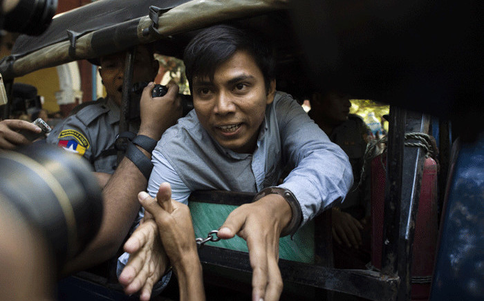 FILE: Reuters journalist Kyaw Soe Oo (C) talks to the media as he leaves after a court appearance in Yangon on 10 January 2018. Picture: AFP.