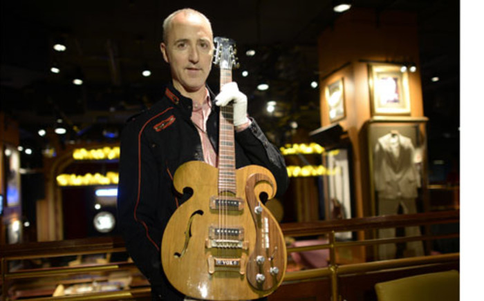 New York : Martin Nolan, Executive Director of Julien's Auction's, holds a rare Vox guitar, played by Beatles John Lennon and George Harrison. Picture:AFP PHOTO. 