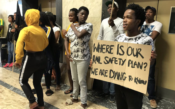 A protester holds a placard outside the Prasa offices in Cape Town on 17 April 2019. Picture: Kaylynn Palm/EWN. 
