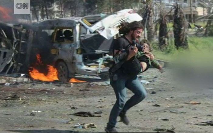 FILE: A screengrab shows Abd Alkader Habak, a photographer and activist, running with a boy in his hands after a bomb attack in Syria. Picture: CNN.