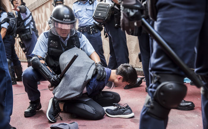FILE: Police detain a man after fights broke out inside a shopping mall between pro-China supporters and anti-government protesters in the Kowloon Bay district of Hong Kong on 14 September 2019. Picture: AFP