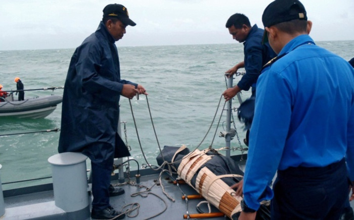 This handout photo made available on December 31, 2014 by Malaysias Ministry of Defence shows Royal Malaysian Navy search and rescue crews retrieving a victim from AirAsia flight QZ8501 during their search and rescue operations in Indonesias Java Sea. Picture: AFP/Malaysian Royal Navy.