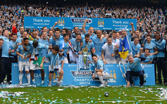 The Manchester City squad pose for pictures with the trophy after they won the Premiership title race following a 2-0 victory in the English Premier League football match between Manchester City and West Ham United at the Etihad Stadium in Manchester on May 11, 2014. Picture: AFP.