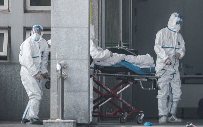 FILE: Medical staff members carry a patient into the Jinyintan hospital, where patients infected by a mysterious SARS-like virus are being treated, in Wuhan in China's central Hubei province on 18 January 2020. Picture: AFP