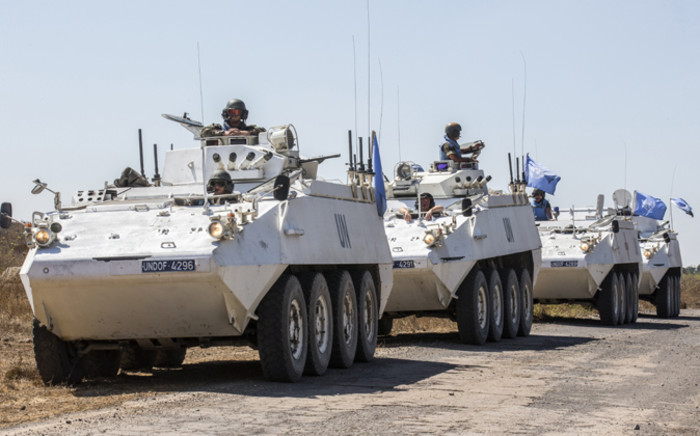  Irish members of the United Nations Disengagement Observer Force (UNDOF) sit on their armoured vehicles in the Israeli-annexed Golan Heights as they wait to cross into the Syrian-controlled territory, on 28 August, 2014.