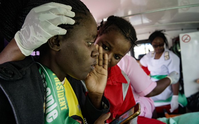 A paramedic attends to an injured Zanu-PF supporter inside an ambulance on the way to Mpilo hospital on 23 June 2018 in Bulawayo, Zimbabwe, after a bomb blast at a campaign rally at White City stadium. Picture: AFP.