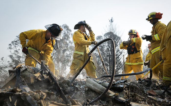 Firefighters search through the remains of a home in the Fountaingrove neighborhood for a strongbox and a wedding ring on October 13, 2017 in Santa Rosa, California. Picture: AFP.