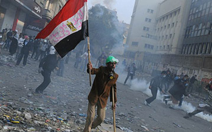 Demonstrators dodge tear gas during clashes in a Cairo street on November 22, 2011. Picture: AFP