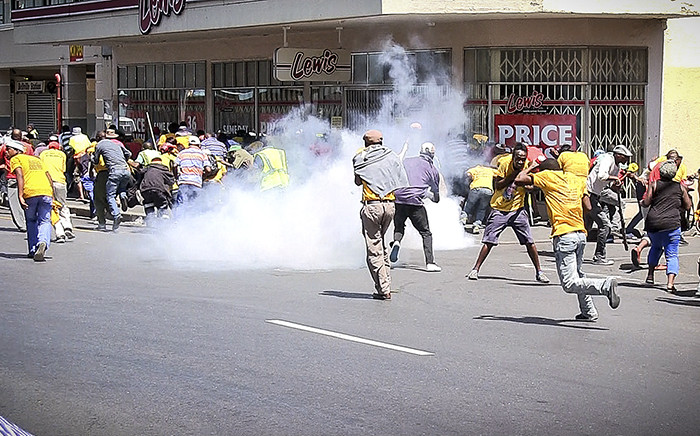 Police use a stun grenade to disperse marching Ses'Khona members who were fighting with Somali nationals near Bellville Station. It is unclear who started the fight. Picture: Thomas Holder/EWN