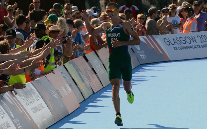Triathlete Richard Murray acknowledges the crowd as he heads down the home straight in the men's event at the 2014 Commonwealth Games. Picture: SASCOC