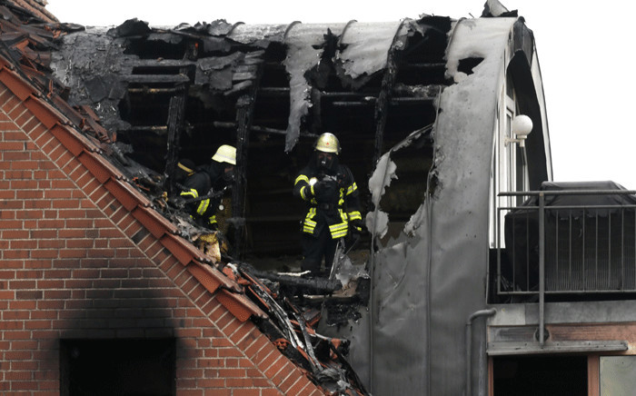Firemen inspect a house after an ultralight aircraft crashed into a house in Wesel, western Germany, 25 July 2020. According to the fire department, three people were killed and a small child was injured. Picture: AFP