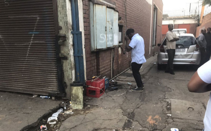 Foreign nationals in Pretoria CBD fix and weld their gate, saying they will hide inside to protect their shops and stock after a day of protests. Picture: Clement Manyathela/EWN.