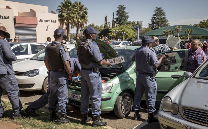 Police inspect a suspected vehicle of licensing fraud at the Rand West City Local Municipality. The owner had numerous registration papers and license plates in the vehicle, and the license disk did not match the registration plates. Picture: Thomas Holder/EWN.