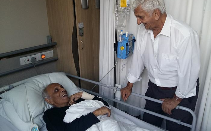 This handout picture taken on March 4, 2017, and obtained on March 5, 2017 from the Ahmed Kathrada Foundation shows ANC stalwart Ahmed Kathrada (L) recovering after a surgery in a hospital in Johannesburg, being comforted by fellow Robben Island former prisoner, Laloo Chiba. Picture: AFP
