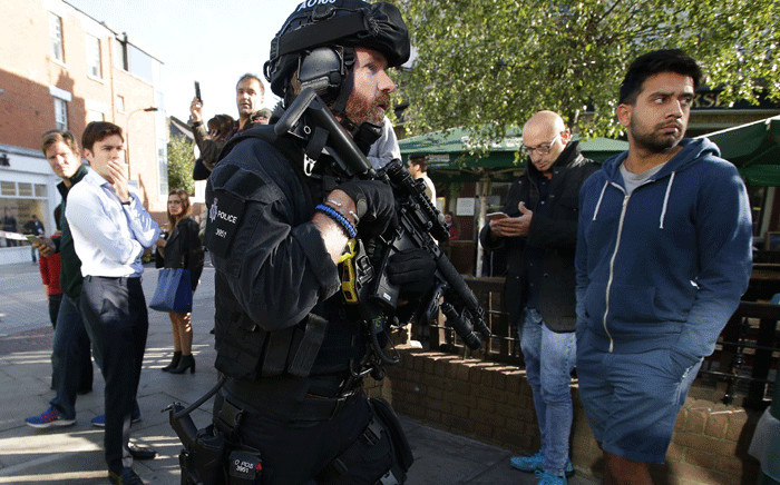Armed British police officers stand on duty outside Parsons Green underground tube station in west London on 15 September 2017. Picture: AFP.